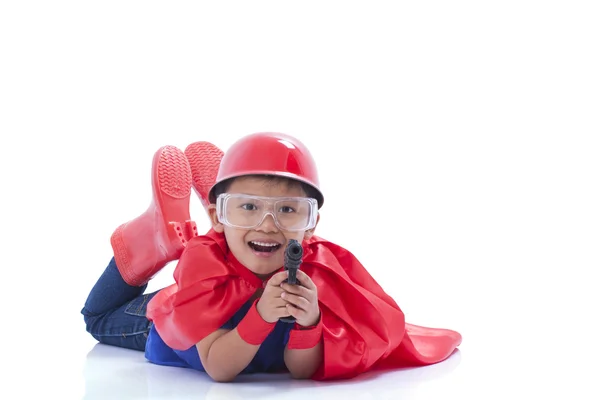 Criança fingindo ser um super-herói com arma de brinquedo no fundo branco — Fotografia de Stock