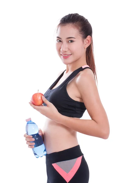 Mujer joven fitness sosteniendo una botella de agua y una manzana sobre fondo blanco —  Fotos de Stock