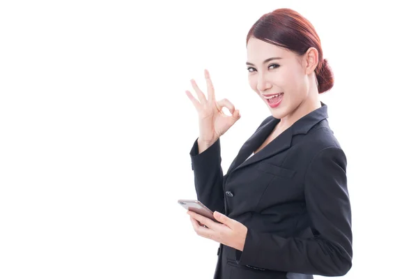 Retrato de una joven mujer de negocios usando un teléfono móvil y mostrando un signo aceptable —  Fotos de Stock