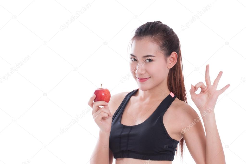 Fitness woman holding apple and showing ok sign