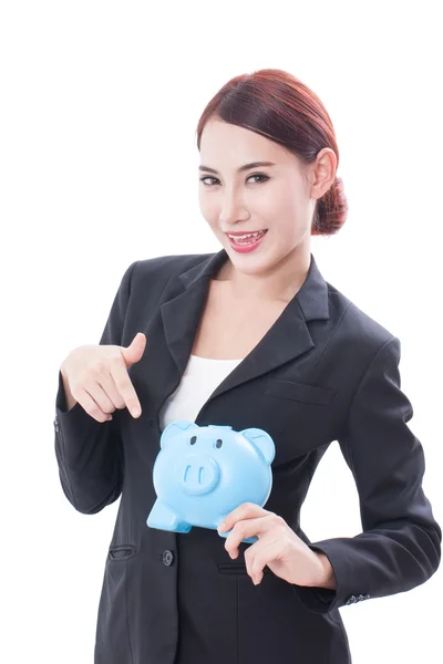 Happy businesswoman pointing at piggy bank — Stock Photo, Image