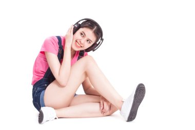 Kulaklıklı genç bir kadın müzik dinliyor.