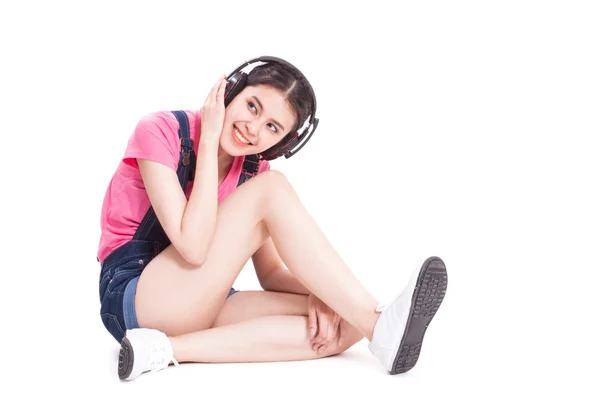 Jonge vrouw met koptelefoon die muziek luistert — Stockfoto