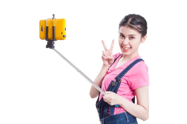 Jeune femme prenant des photos avec smartphone selfie stick — Photo