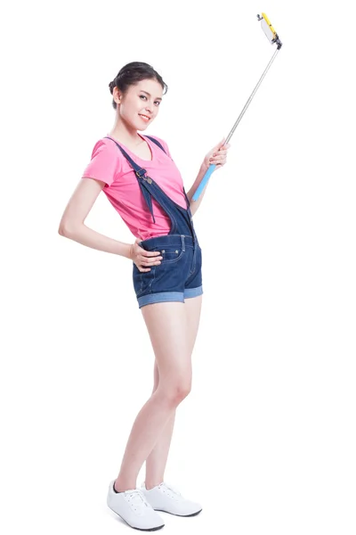 Young woman taking picture with smartphone selfie stick — Stock Photo, Image