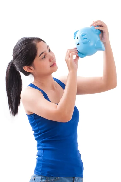 Happy woman pointing at piggy bank — Stock Photo, Image