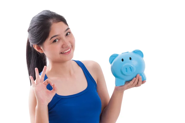 Gelukkig woman wijzend op piggy bank met weergegeven: ok teken geïsoleerd op witte achtergrond — Stockfoto