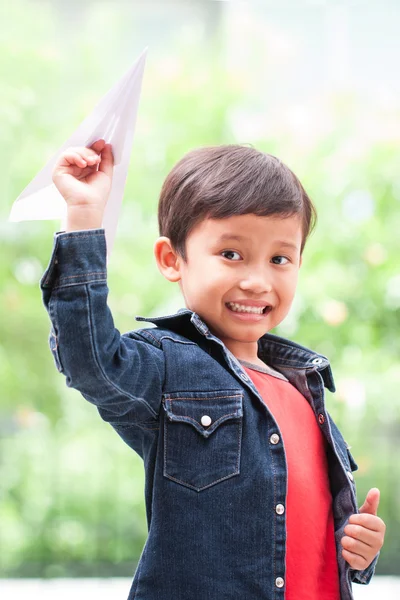 Chlapec hraje s papírovým letadlem — Stock fotografie