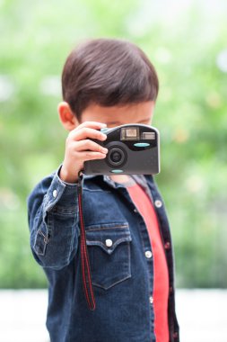 Asyalı çocuk ile kompakt fotoğraf makinesi.