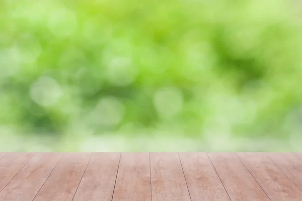 Дерев'яний стіл на зеленому абстрактному фоні — стокове фото