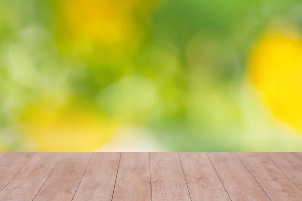 Holztisch auf grünem abstrakten Hintergrund — Stockfoto