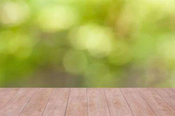 Holztisch auf grünem abstrakten Hintergrund — Stockfoto