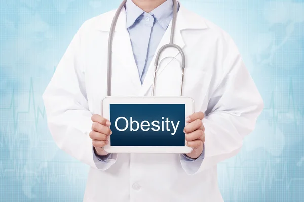 Läkare med tablett och fetma skylt — Stockfoto