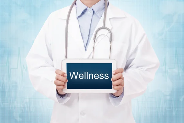 Arzt hält Tablet-PC mit Wellness-Schild. — Stockfoto
