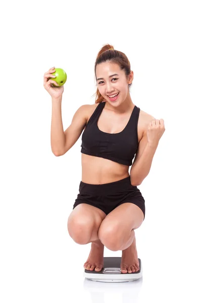 Mujer en escamas de peso con manzana — Foto de Stock