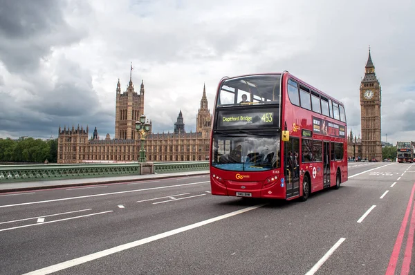 Londra, İngiltere - Temmuz 2012: Kırmızı çift katlı bir Londra otobüsü köprüden Parlamento önünde geçiyor