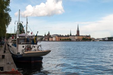 Stockholm 'ün arka planında evleri, köprüsü ve kulesi olan liman bölgesi.