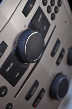 Siyah düğmeleri ve gümüş arkaplanı olan bir arabanın (radyo ve klima kontrolü) yakın görüntüsü