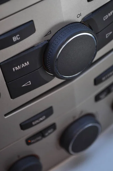 Close-up view of a car dashboard (radio and air conditioning control) with black buttons and a silver background