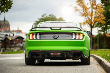 Çek Cumhuriyeti - 10 Ekim 2025: Ford Mustang GT şehirde caddeye park etti. Mat yeşil renkli hızlı Amerikan spor arabası. V8 benzinli kaslı araba..