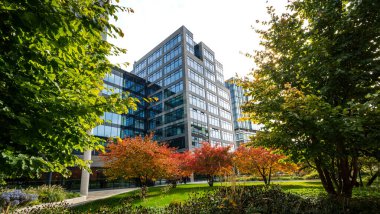 Şehir merkezindeki modern ofis bölgesi. Yaya geçidi olan yeni binalar ve iş merkezinde ağaçlar olan küçük bir park..