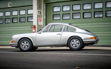 Brno, Czech Republic - October 24, 2025: Old luxury sports car Porsche 911 outdoors on a race track. Silver fast German car.