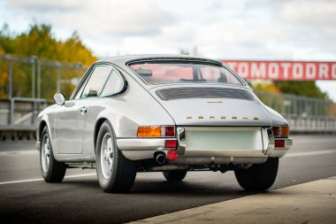 Brno, Czech Republic - October 24, 2025: Old luxury sports car Porsche 911 outdoors on a race track. Silver fast German car.
