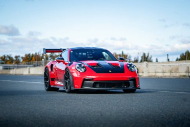 Brno, Czech Republic - October 24, 2025: Red Porsche 911 GT3 RS sports car outdoors in a parking lot at a race track.