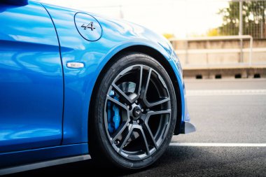 Brno, Czech Republic - October 24, 2025: Detail of the front wheel of a blue Alpine A110 sports car made in France.