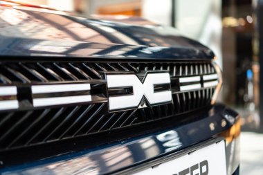 Brno, Çek Cumhuriyeti - 31 Aralık 2023: Büyük bir SUV Dacia Bigster ailesinin beyaz logosuyla ön ızgaranın ayrıntıları. Aile arabası alışveriş merkezine park edilmiş..