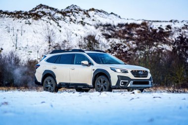 Brno, Çek Cumhuriyeti - 20 Ocak 2025: Beyaz Subaru Outback aile arabası açık havada bir çayırda. Japon cipi kışın kırsalda karda.