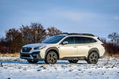 Brno, Çek Cumhuriyeti - 20 Ocak 2025: Beyaz Subaru Outback aile arabası açık havada bir çayırda. Japon cipi kışın kırsalda karda.