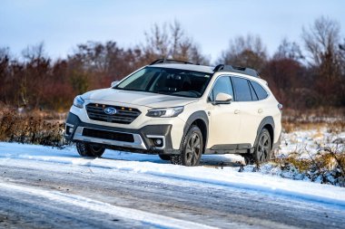 Brno, Çek Cumhuriyeti - 20 Ocak 2025: Beyaz Subaru Outback aile arabası açık havada bir çayırda. Japon cipi kışın kırsalda karda.
