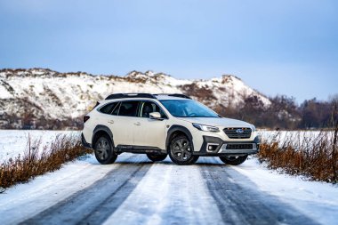Brno, Çek Cumhuriyeti - 20 Ocak 2025: Beyaz Subaru Outback aile arabası açık havada bir çayırda. Japon cipi kışın kırsalda karda.