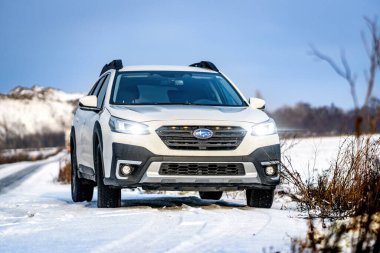 Brno, Çek Cumhuriyeti - 20 Ocak 2025: Beyaz Subaru Outback aile arabası açık havada bir çayırda. Japon cipi kışın kırsalda karda.