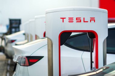Brno, Çek Cumhuriyeti - 31 Aralık 2025: Tesla arabası hızlı şarj istasyonuna takıldı. Sokaktaki bir şarj aletine elektrikli araçlar yüklüyorlar..