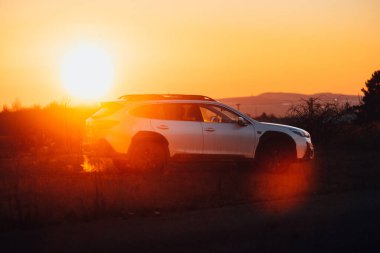 Brno, Çek Cumhuriyeti - 10 Şubat 2026: Japon off-road otomobili Subaru Outback doğada kışın gün batımında bir arazide duruyor. Yolculukta beyaz bir SUV 'a radyasyon.