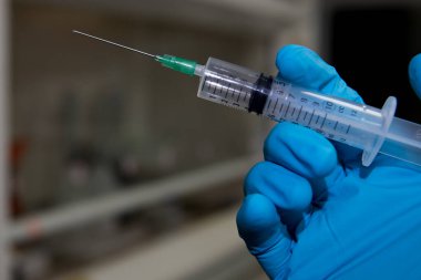 Coronavirus aşısı bağışıklık aşısı için hazır. Eldivenli doktor elinde şırınga ve aşı ile