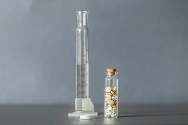 Gri arka planda cam bir kavanozda ilaç karışımı. Tıbbi ve sağlık hizmetleri konsepti. Seçici odak.