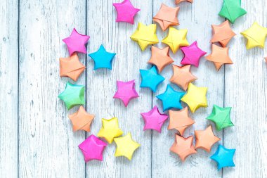 Beyaz tahta sırtında çok renkli origami kağıt yıldızı. Üst görünüm.