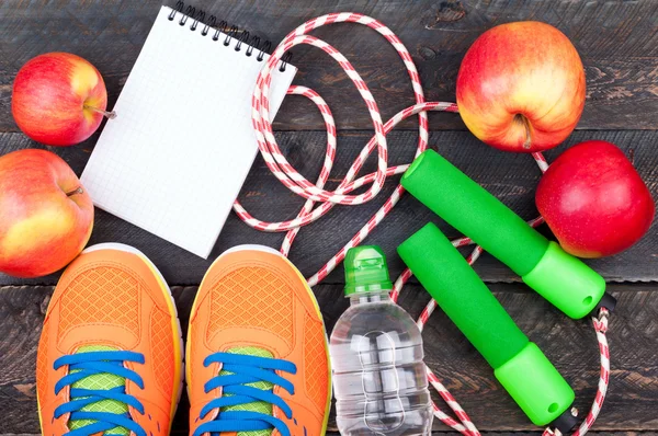 Zapatillas deportivas, cuerda de salto, manzana, botella de agua y blan abierto — Foto de Stock