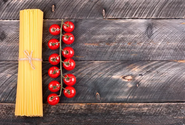 Spaghetti and tomatoes on old rustic background. Ingredients for — Stock Photo, Image