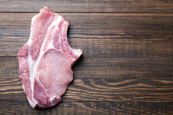 Carne de cerdo cruda en una mesa de madera con espacio para copiar. Fondo alimentario —  Fotos de Stock