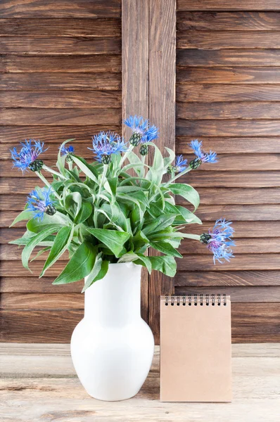 Bouquet de bleuets et carnet ouvert. Fleurs d'été sur fond en bois. Carte de vacances — Photo