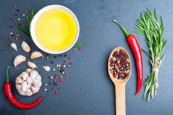 Especiarias - alecrim, óleo de azeitona, pimentão em uma colher, pimentão, alho e óleo de azeitona na pedra escura. Ingredientes para cozinhar — Fotografia de Stock