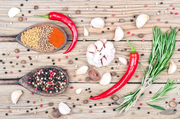 Pozadí koření s kopií prostoru. Rosemary, pepř, paprika, pískavice, koriandr, chilli a česnek na dřevěné pozadí — Stock fotografie