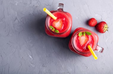 Çilek smoothies Cam Kavanoz, çilek ve kopya alanı taş zemin üzerine nane. Yaz meyveleri vitamin içeceği. Sağlıklı gıda