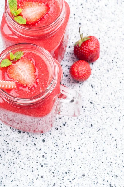 Bebida de verão smoothies de morango em frasco de vidro, bagas e hortelã em fundo branco com espaço de cópia — Fotografia de Stock