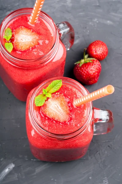 Summer drink strawberry smoothies in glass jar, berries and mint on stone background with copy space. Healthy food — Stock Photo, Image