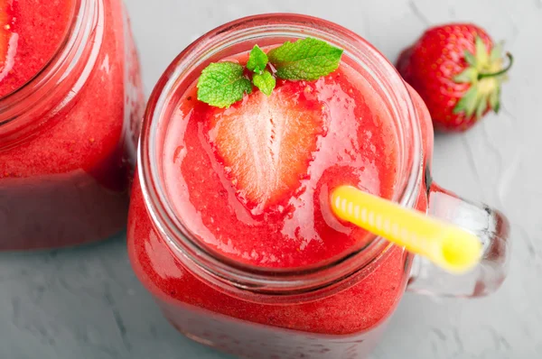 Strawberry smoothies in glass jar and strawberry on stone background closeup. Healthy drink — Stock Photo, Image